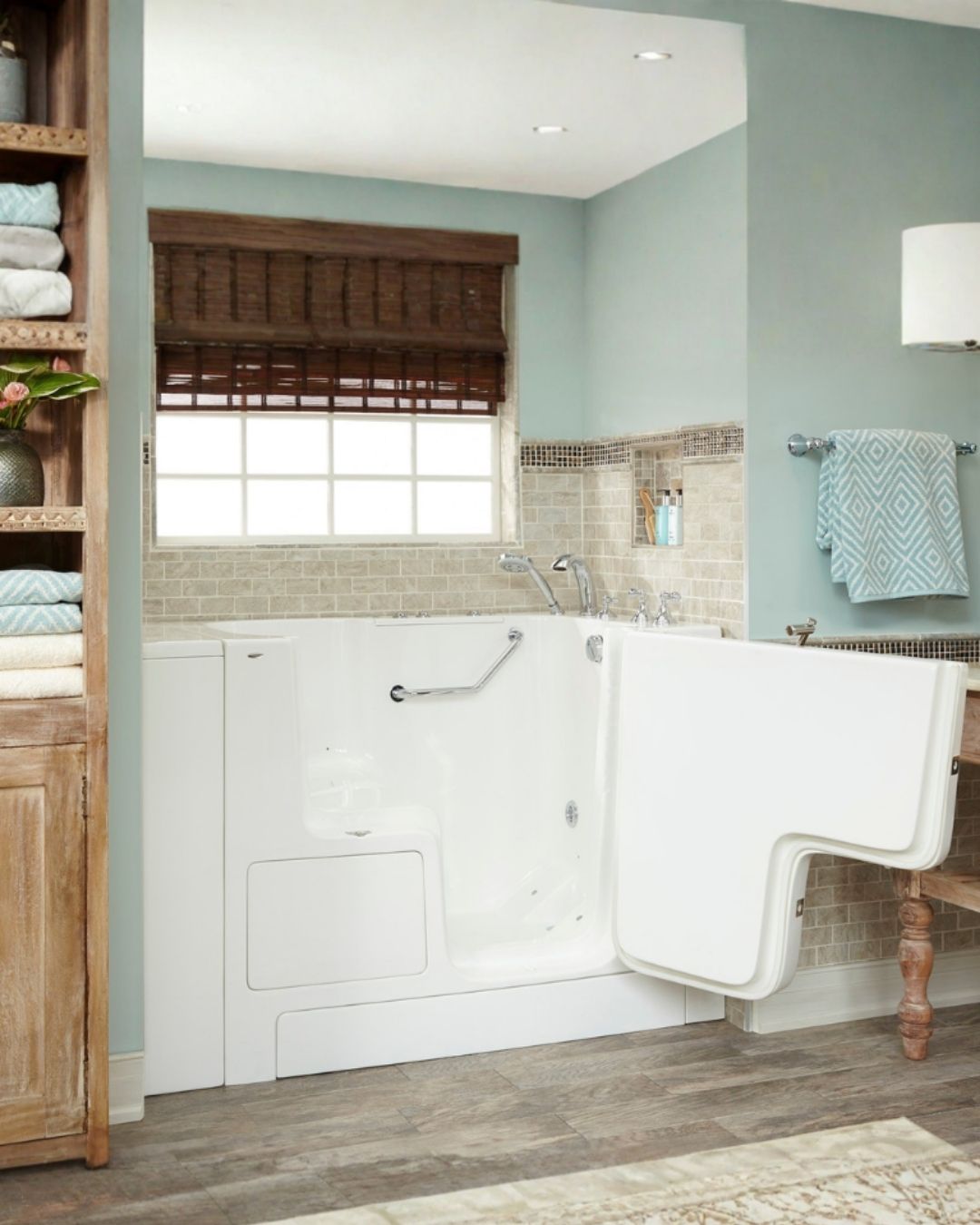 Walk-in tub installation by The Bath Authority with outward-swinging door, safety grab bar, hydrotherapy features, and accessible bathroom design for seniors and individuals with mobility needs.