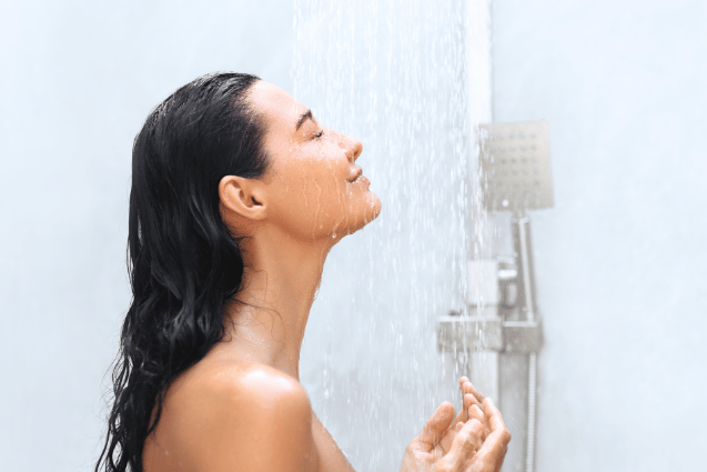 Woman enjoying a relaxing shower beneath a modern rainfall showerhead.