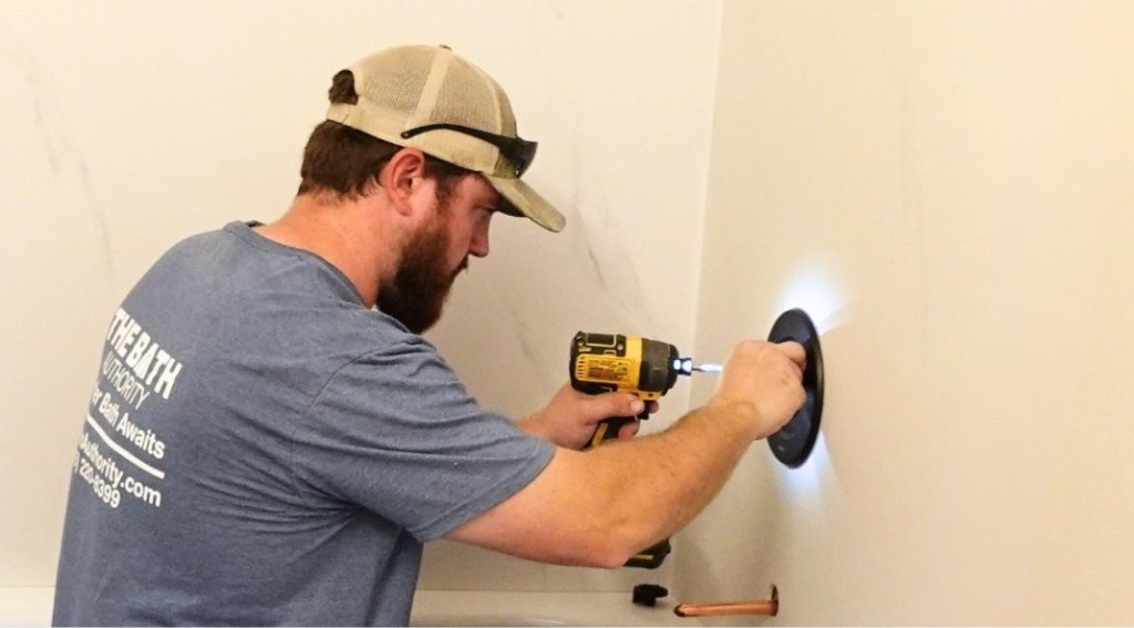 A factory-trained bathroom expert completes a shower handle installation.