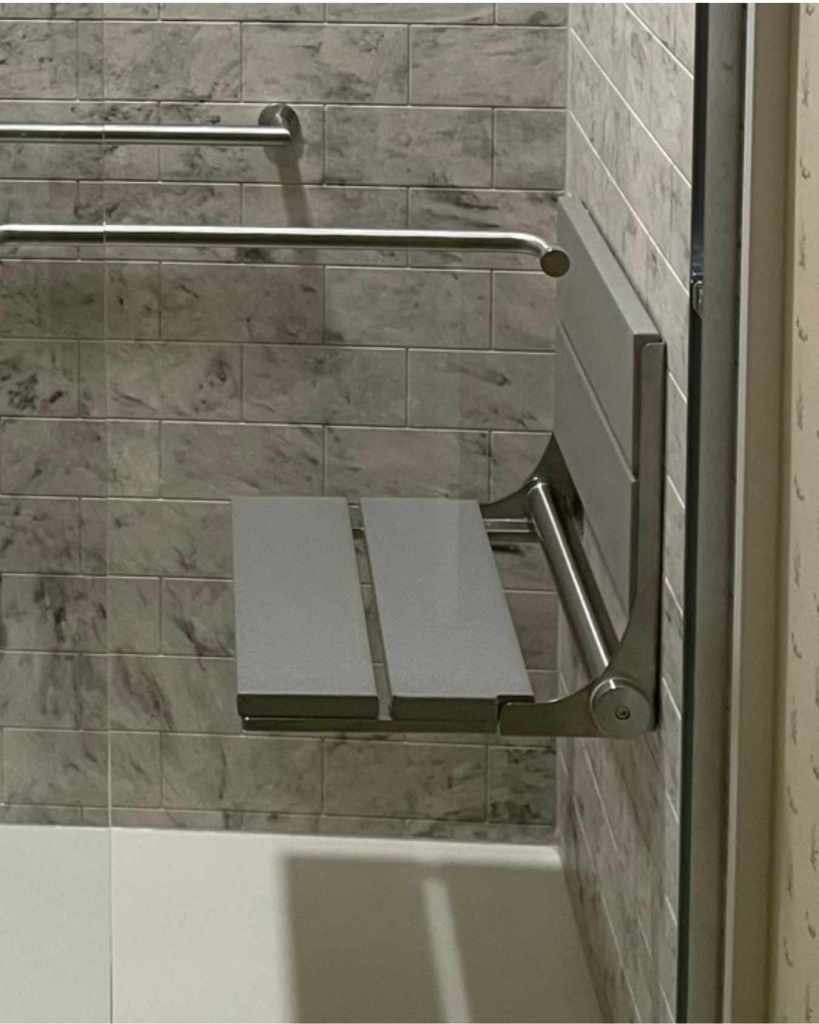 Fold down shower seat with chrome finishes