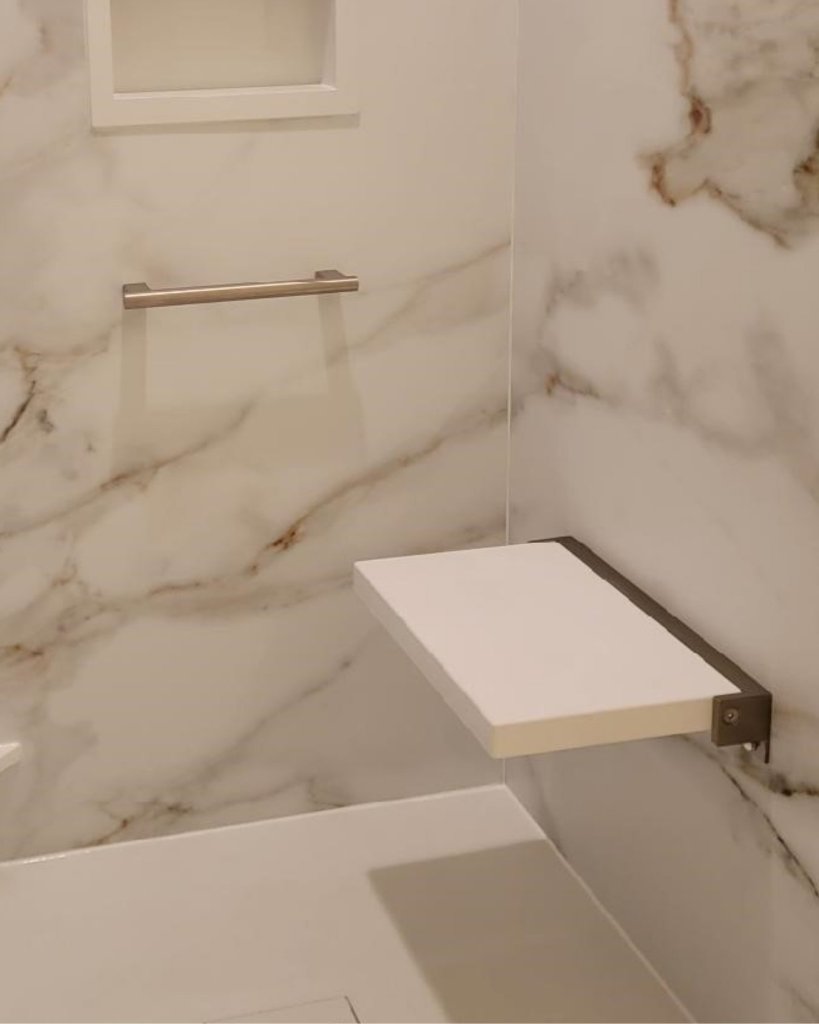 A modern walk-in shower with a fold down seat and stylish grab bar.